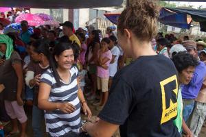 A member of the IRC distributes aid in the Philippines. (Credit: The International Rescue Committee)